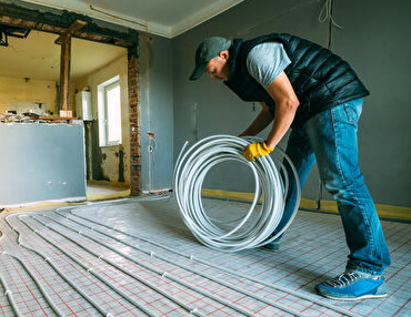 technician installing radiant floor heating system